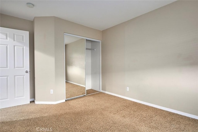 unfurnished bedroom featuring carpet flooring and a closet