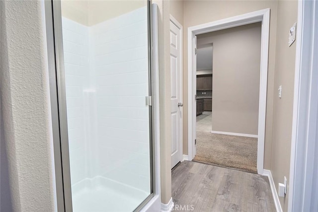 bathroom with wood-type flooring and an enclosed shower