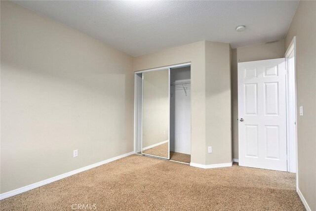 unfurnished bedroom with carpet floors and a closet