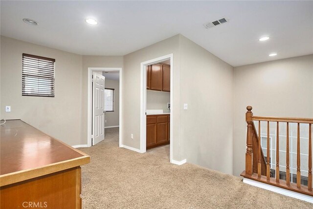 hall featuring light colored carpet