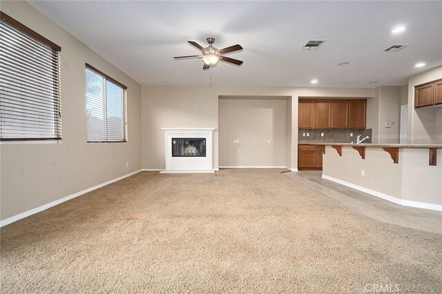 unfurnished living room featuring ceiling fan