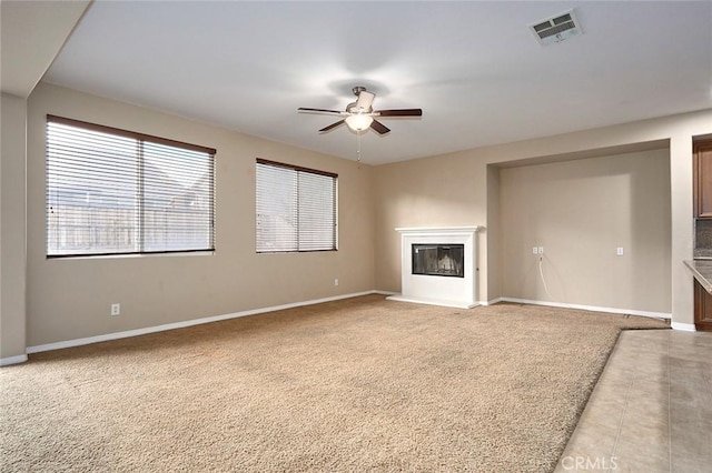 unfurnished living room featuring ceiling fan and light carpet