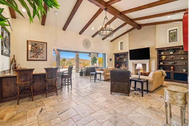 living room featuring beamed ceiling, bar, a chandelier, and high vaulted ceiling