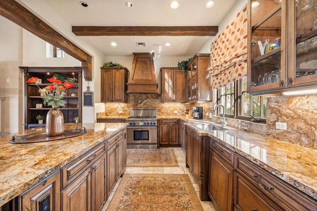 kitchen with sink, high end stainless steel range, light stone countertops, custom range hood, and beamed ceiling