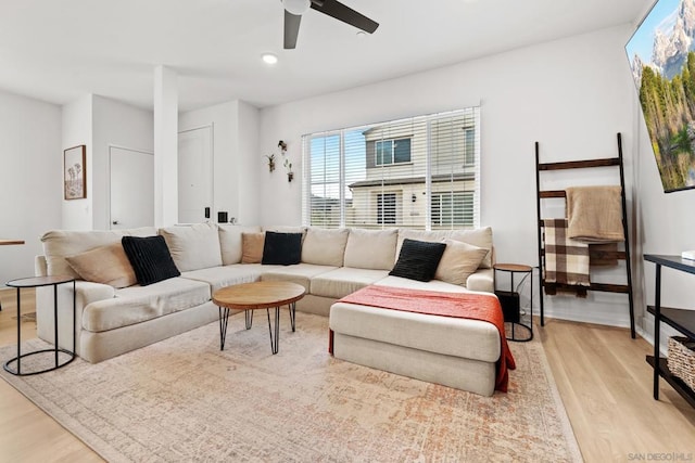 living room featuring light hardwood / wood-style flooring and ceiling fan