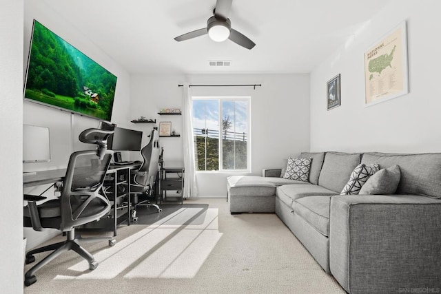 carpeted office space with ceiling fan