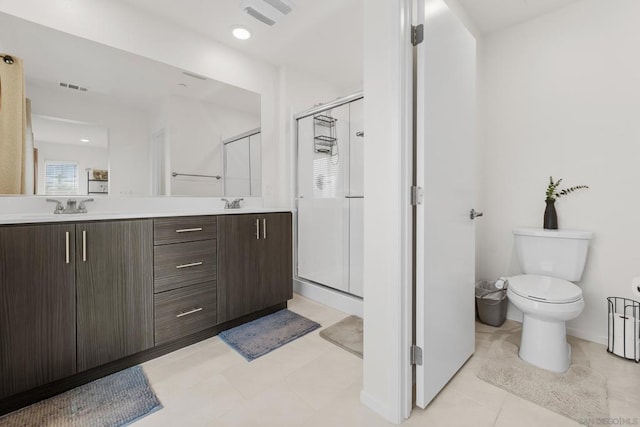 bathroom with a shower with door, vanity, and toilet