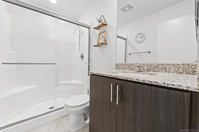 bathroom with an enclosed shower, vanity, tile patterned floors, and toilet