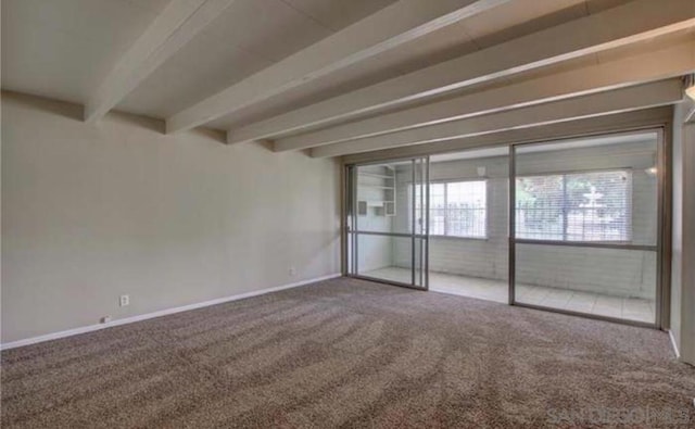 empty room with carpet floors and beam ceiling