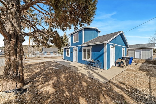 back of house with a patio and a storage unit