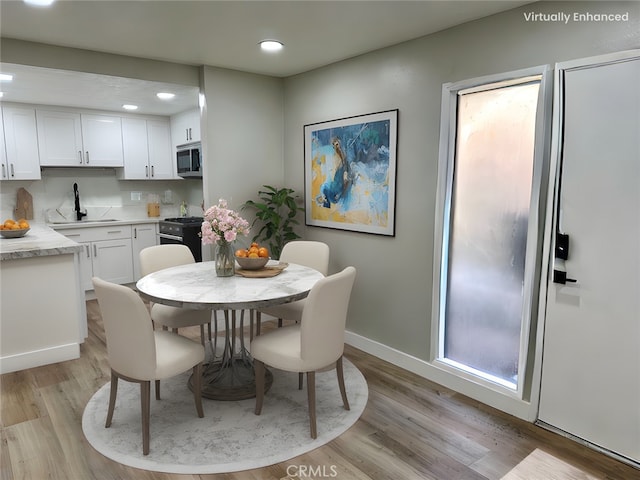 dining space featuring sink and light wood-type flooring