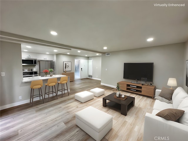 living room with sink and light hardwood / wood-style floors