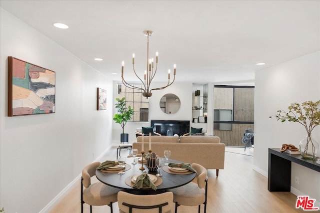 dining space featuring an inviting chandelier and light wood-type flooring