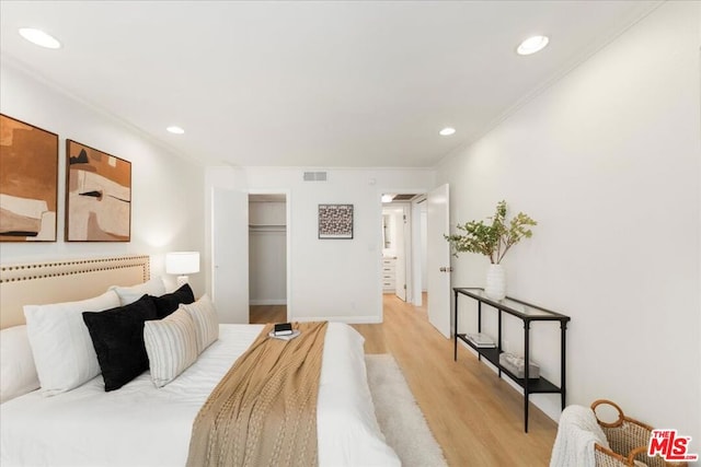 bedroom featuring ornamental molding, light hardwood / wood-style floors, and a closet