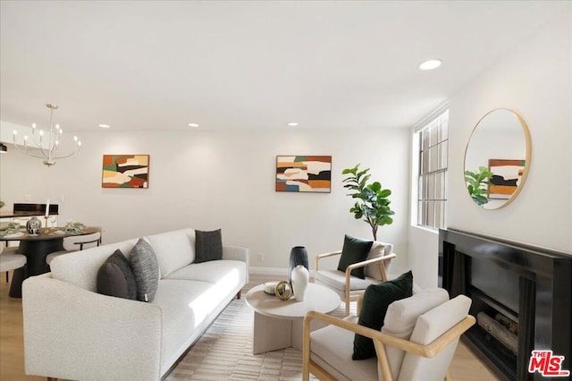 living room with an inviting chandelier and light hardwood / wood-style floors