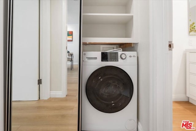 laundry room featuring washer / dryer and light hardwood / wood-style flooring