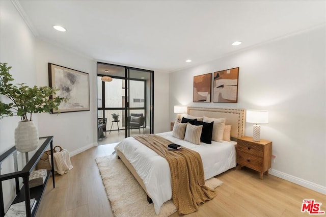 bedroom with crown molding, floor to ceiling windows, and light hardwood / wood-style flooring