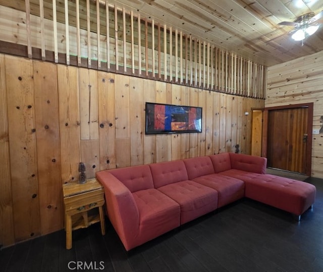 living area with wood ceiling, wooden walls, wood-type flooring, and ceiling fan