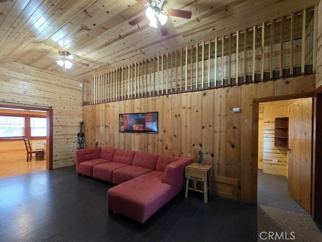 living area with wooden ceiling, wooden walls, and a ceiling fan