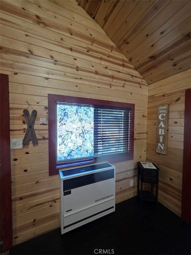 bedroom featuring wooden ceiling, wood walls, vaulted ceiling, and heating unit