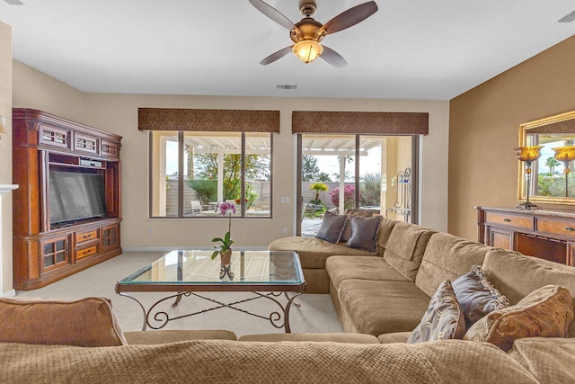 carpeted living room featuring ceiling fan and a healthy amount of sunlight