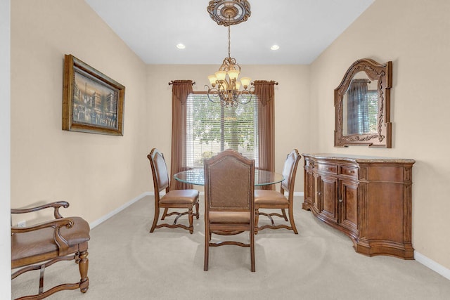 dining space featuring light colored carpet and a chandelier