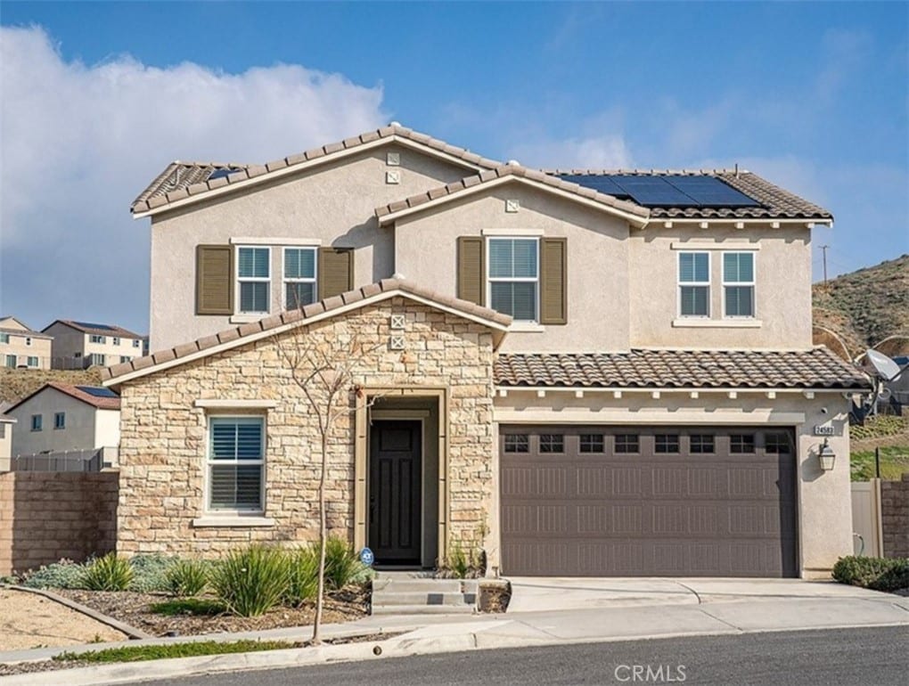 view of front of property featuring a garage and solar panels