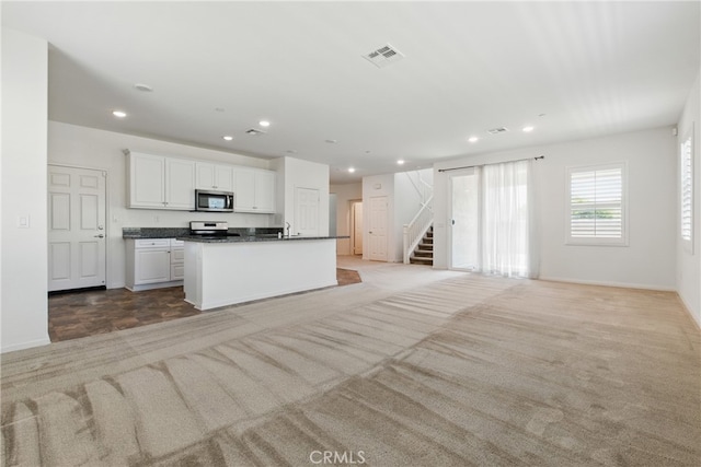24583 Acadia Dr, Corona, CA 92883 - kitchen with stainless steel appliances, dark countertops, white cabinetry, open floor plan, and recessed lighting