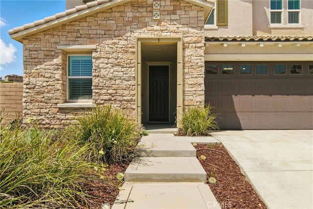 24583 Acadia Dr, Corona, CA 92883 - view of front facade featuring stone siding, driveway, an attached garage, and a tiled roof