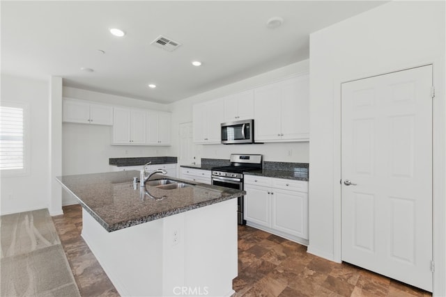 24583 Acadia Dr, Corona, CA 92883 - kitchen featuring appliances with stainless steel finishes, white cabinets, a center island with sink, dark stone countertops, and recessed lighting