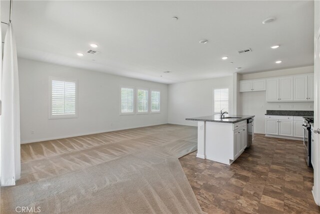 24583 Acadia Dr, Corona, CA 92883 - kitchen with dark countertops, appliances with stainless steel finishes, open floor plan, white cabinets, and recessed lighting
