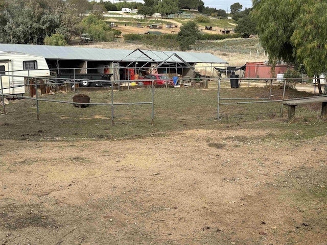 view of yard with an outdoor structure and a rural view