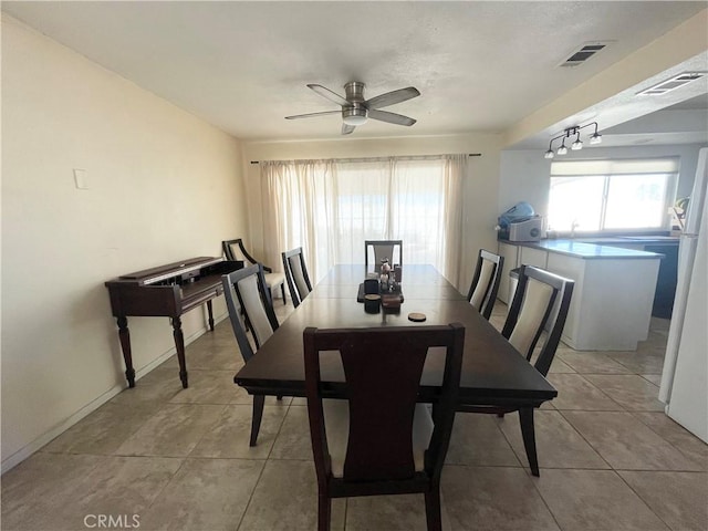 dining space with light tile patterned floors, visible vents, and a ceiling fan