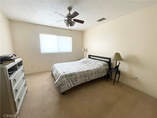 carpeted bedroom with ceiling fan and visible vents