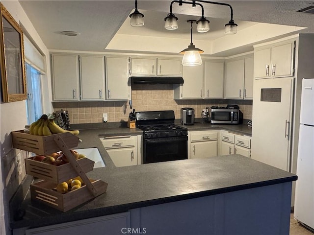 14376 Rivers Edge Rd, Helendale, CA 92342 - kitchen with stainless steel microwave, dark countertops, gas stove, and a raised ceiling