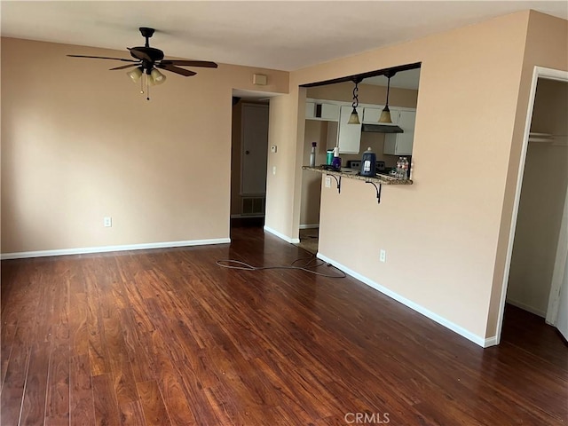 unfurnished living room with ceiling fan and dark hardwood / wood-style flooring