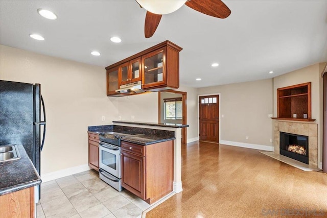 kitchen with black refrigerator, kitchen peninsula, dark stone counters, and stainless steel range with electric stovetop