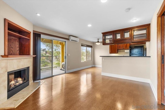 unfurnished living room featuring a tiled fireplace, ceiling fan, and a wall mounted AC