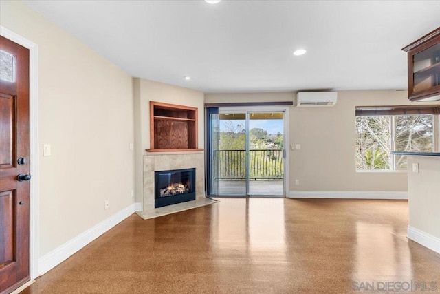 unfurnished living room featuring a tile fireplace and a wall unit AC