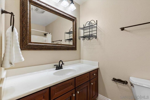 bathroom featuring vanity, curtained shower, and toilet