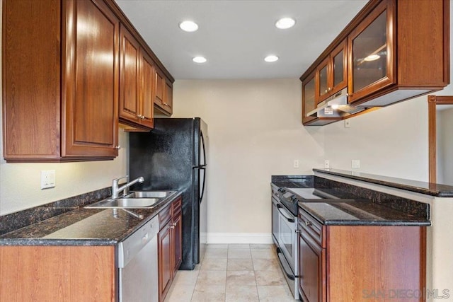 kitchen featuring sink, stainless steel appliances, and dark stone counters