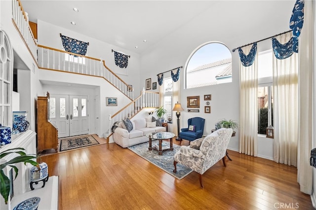 living room featuring wood-type flooring and a high ceiling