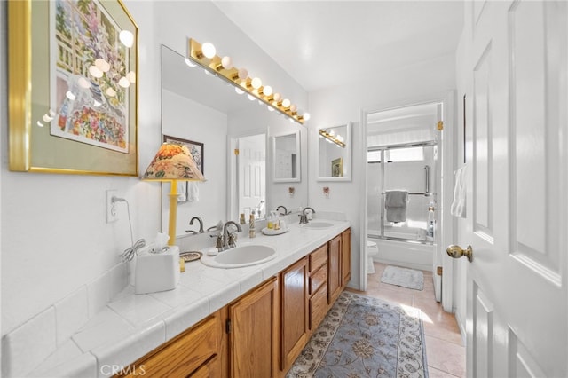 full bathroom with tile patterned flooring, enclosed tub / shower combo, vanity, and toilet