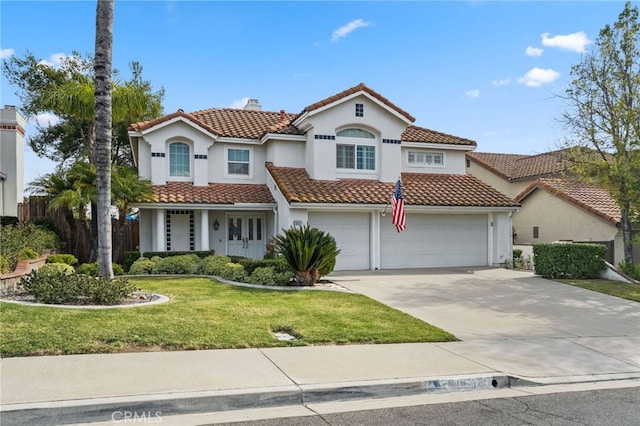 mediterranean / spanish house with a garage and a front yard