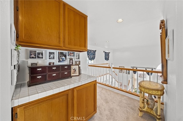 kitchen with tile countertops and light carpet