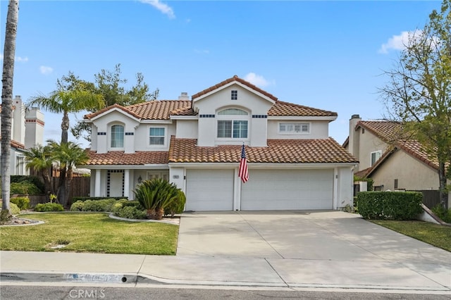 mediterranean / spanish home featuring a garage and a front lawn