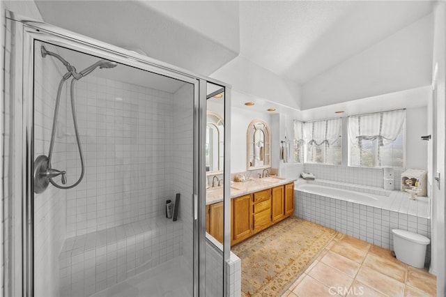 bathroom featuring vanity, vaulted ceiling, tile patterned floors, and separate shower and tub