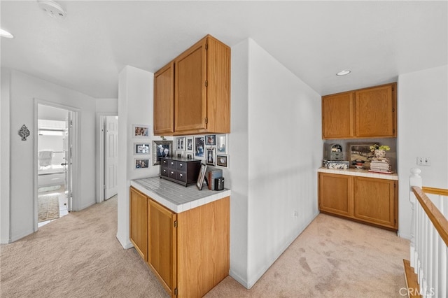 kitchen featuring light carpet and tile counters