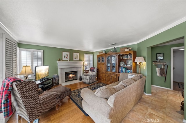 living room featuring ornamental molding and a fireplace