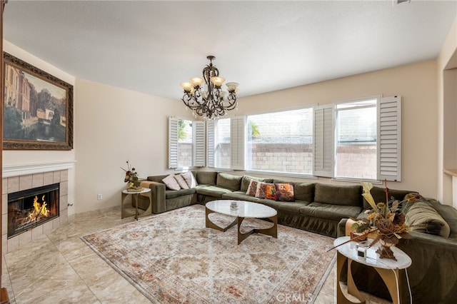 living room featuring a tiled fireplace and a notable chandelier